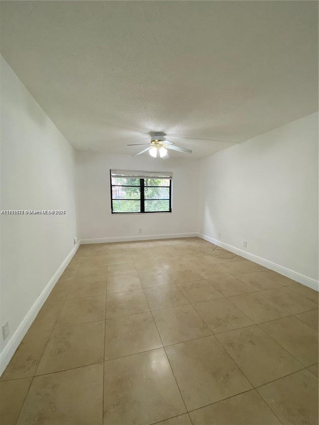 empty room with light tile patterned floors and ceiling fan