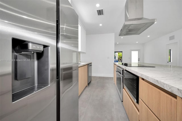 kitchen with light stone counters, light brown cabinets, stainless steel appliances, and island exhaust hood