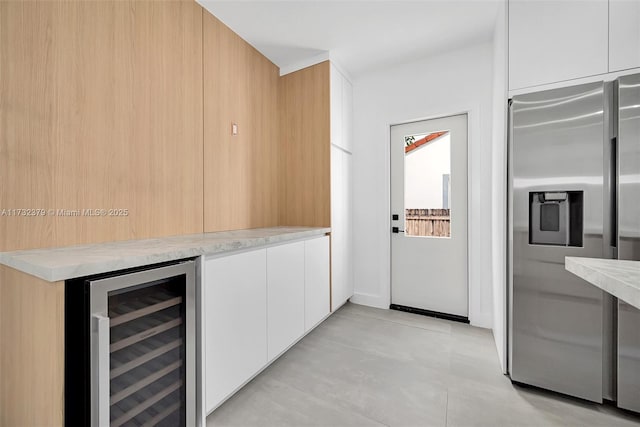 kitchen with wine cooler, stainless steel fridge, and white cabinets