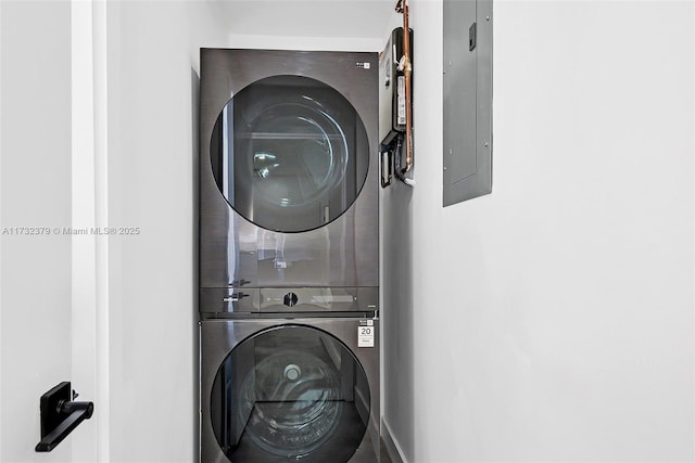 clothes washing area with stacked washer and clothes dryer and electric panel