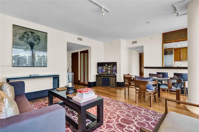 living room featuring hardwood / wood-style flooring and rail lighting