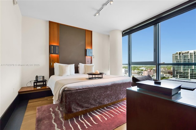 bedroom featuring track lighting and light wood-type flooring