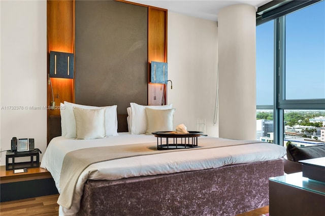 bedroom featuring wood-type flooring and floor to ceiling windows