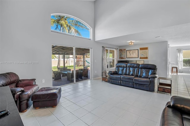 tiled living room featuring plenty of natural light and a high ceiling