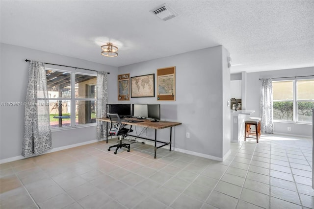 home office featuring light tile patterned flooring and a textured ceiling