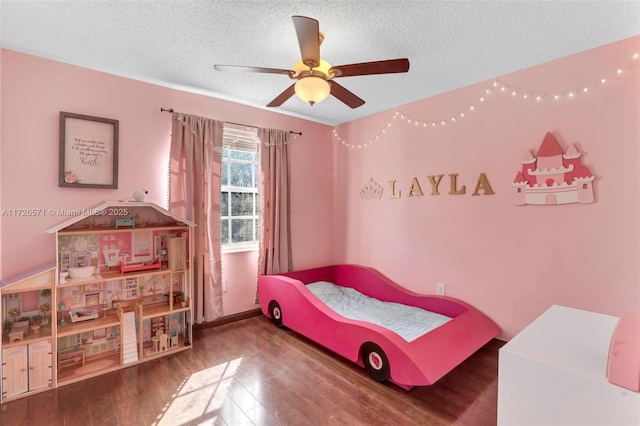 bedroom featuring wood-type flooring, a textured ceiling, and ceiling fan