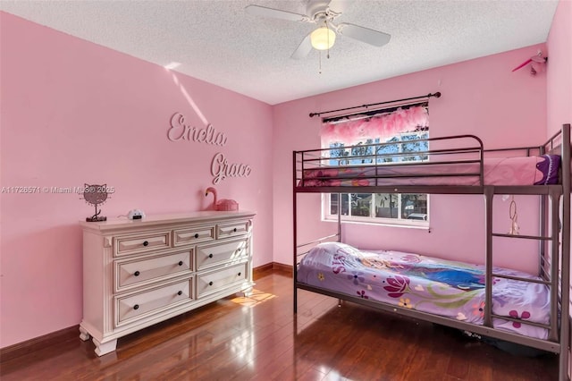 bedroom with hardwood / wood-style floors, a textured ceiling, and ceiling fan