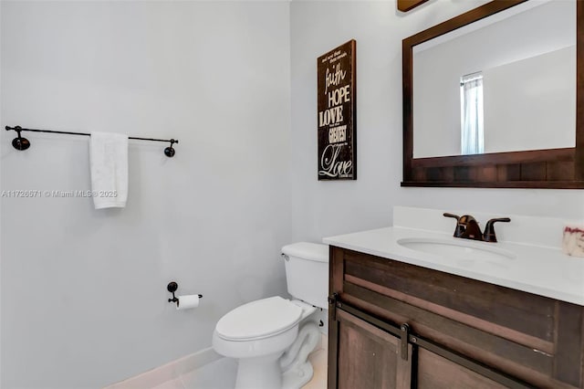 bathroom with tile patterned flooring, vanity, and toilet