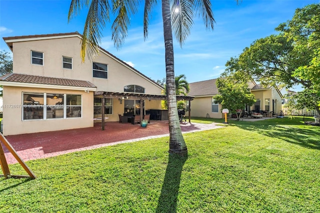 back of house with a pergola, a patio area, and a lawn