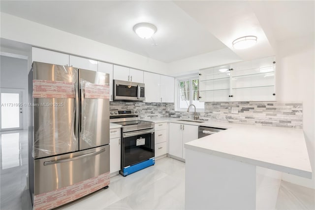 kitchen featuring sink, white cabinets, decorative backsplash, kitchen peninsula, and stainless steel appliances