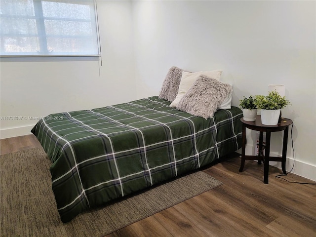 bedroom with baseboards and wood finished floors