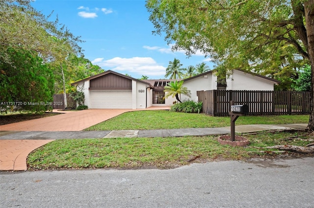 single story home featuring a garage and a front lawn