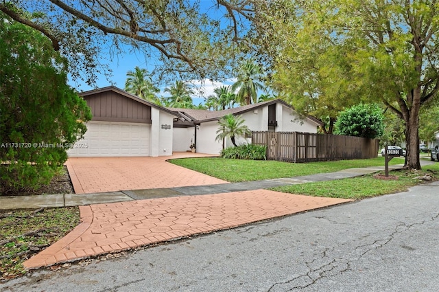 single story home featuring a garage and a front yard