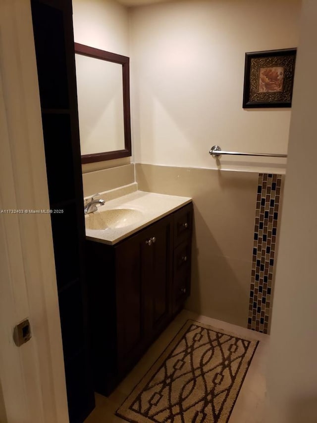 bathroom featuring vanity and tile walls