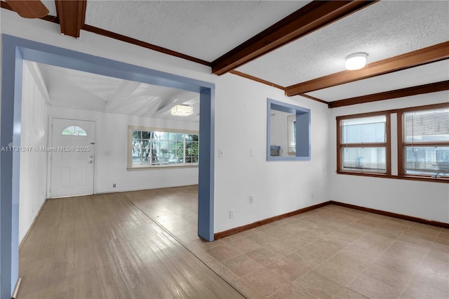 interior space with beam ceiling and a textured ceiling