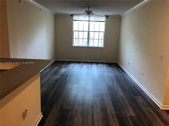 empty room with dark wood-type flooring, ceiling fan, and ornamental molding