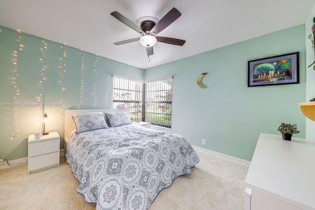 carpeted bedroom featuring ceiling fan and a textured ceiling