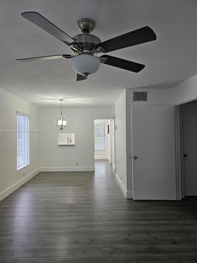 unfurnished room with ceiling fan, dark hardwood / wood-style flooring, and a textured ceiling