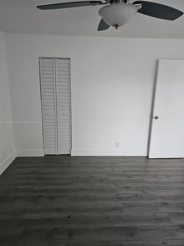 unfurnished bedroom featuring ceiling fan, dark hardwood / wood-style floors, and a closet