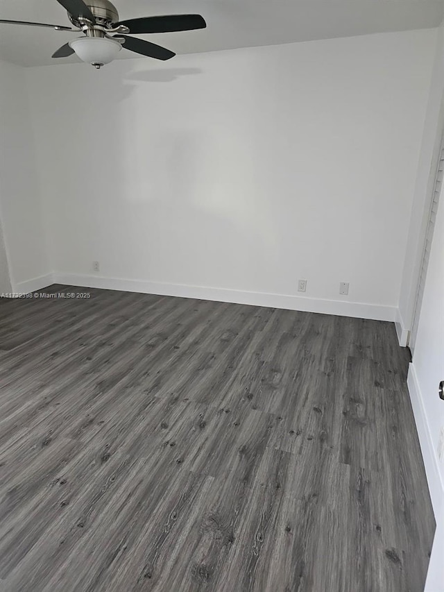 empty room with dark hardwood / wood-style floors and ceiling fan