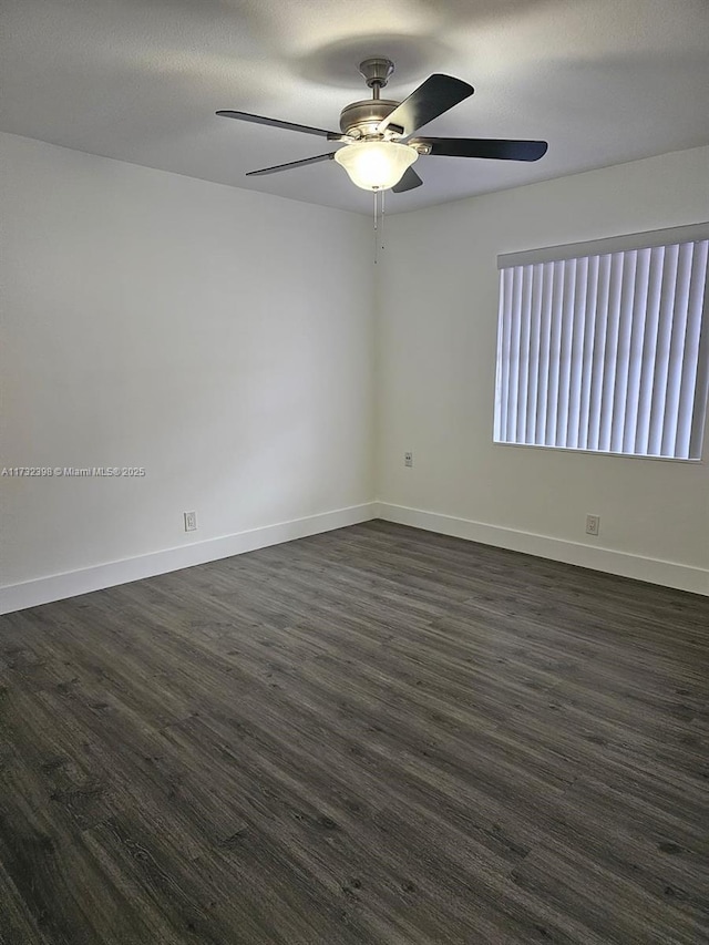 spare room with dark wood-type flooring and ceiling fan