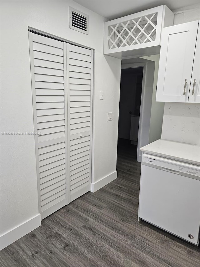 kitchen with white dishwasher, dark hardwood / wood-style flooring, and white cabinets