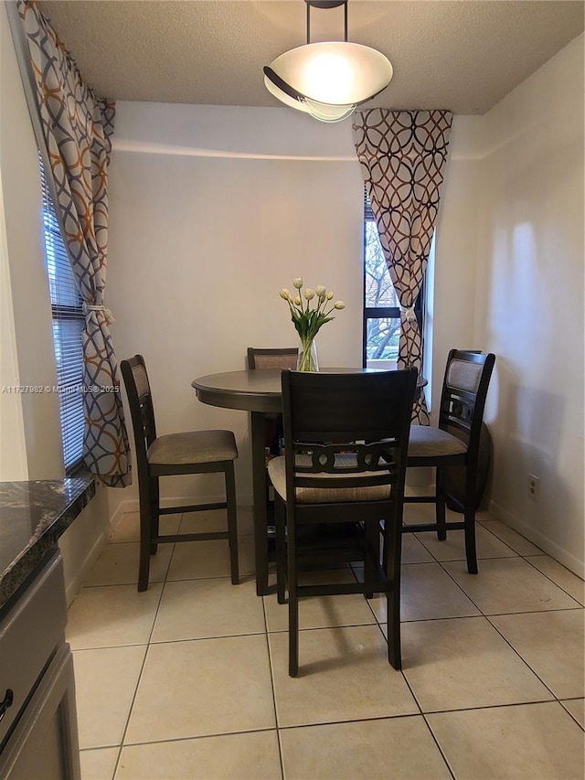 tiled dining area with a textured ceiling