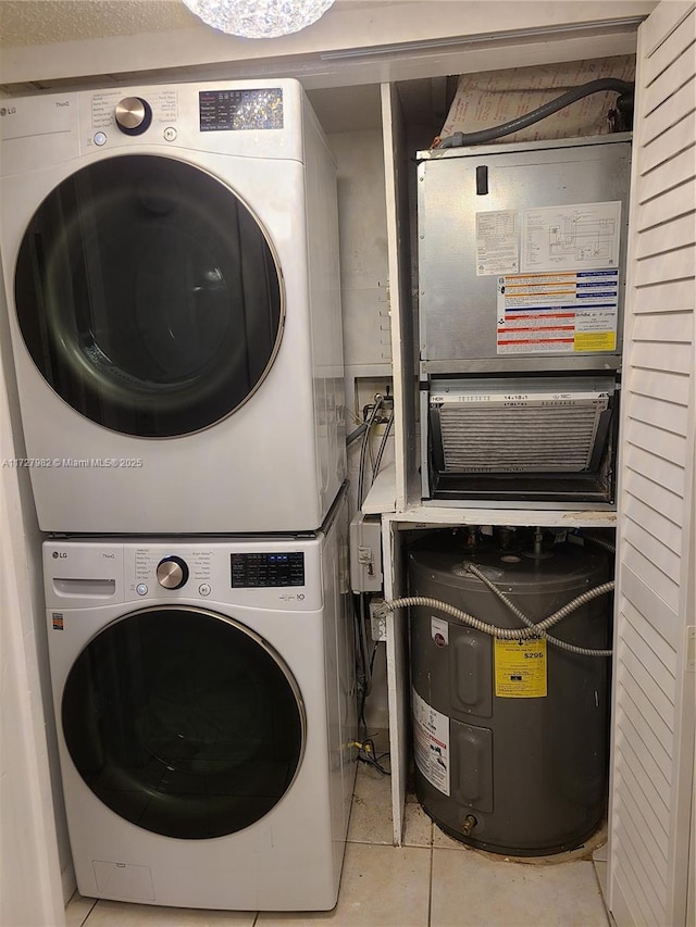 clothes washing area featuring stacked washer and clothes dryer and light tile patterned flooring