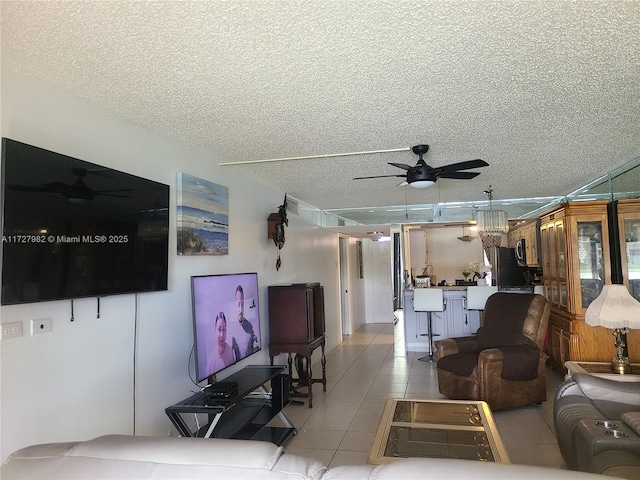 living room with light tile patterned floors, a textured ceiling, and ceiling fan