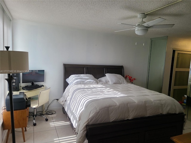 tiled bedroom featuring ceiling fan and a textured ceiling