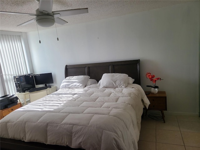 bedroom with a textured ceiling, ceiling fan, and light tile patterned flooring