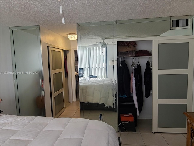 bedroom with tile patterned floors, a closet, and a textured ceiling