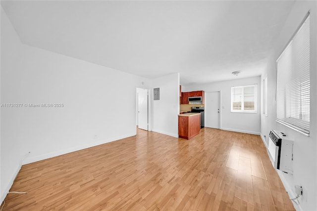 unfurnished living room featuring an AC wall unit and light hardwood / wood-style floors