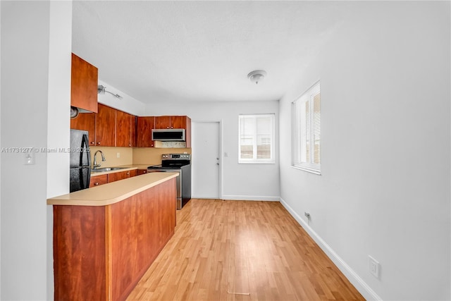 kitchen featuring appliances with stainless steel finishes, light hardwood / wood-style floors, and sink