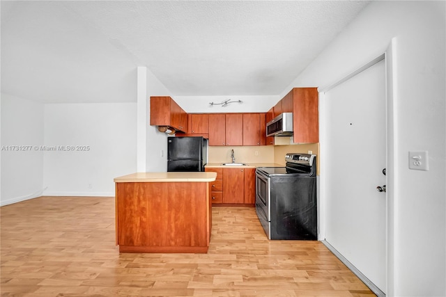 kitchen featuring sink, stainless steel appliances, a textured ceiling, and light wood-type flooring