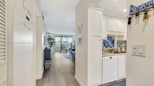 corridor with light hardwood / wood-style floors and sink