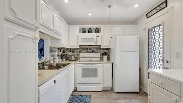 kitchen featuring sink, white appliances, light hardwood / wood-style flooring, white cabinetry, and tasteful backsplash