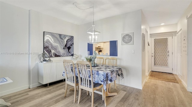 dining area featuring an inviting chandelier and light hardwood / wood-style flooring