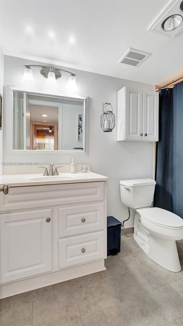 bathroom featuring tile patterned flooring, vanity, and toilet