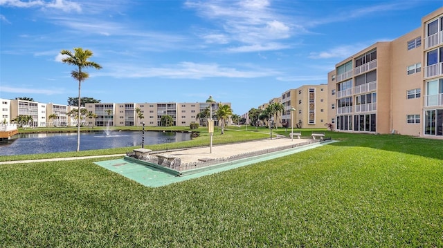 view of community featuring a water view and a yard