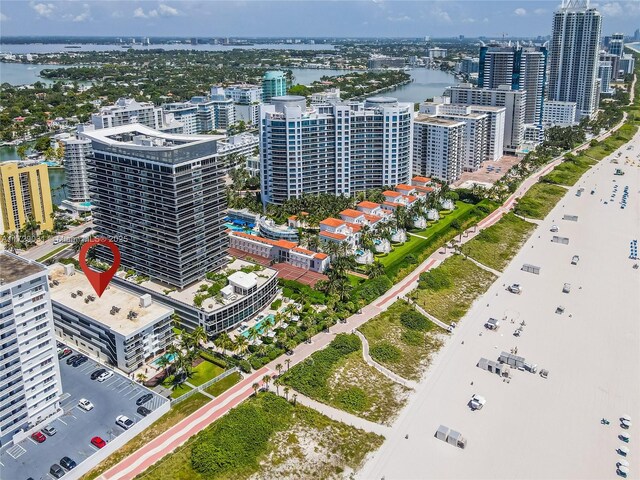 birds eye view of property with a water view and a beach view