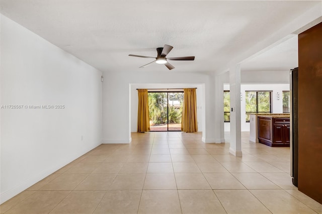 tiled empty room featuring ceiling fan and a textured ceiling