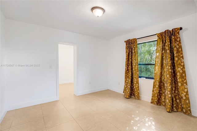 empty room with light tile patterned floors and ceiling fan