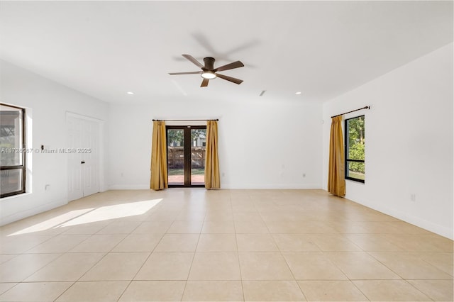 unfurnished room with a wealth of natural light, french doors, ceiling fan, and light tile patterned flooring