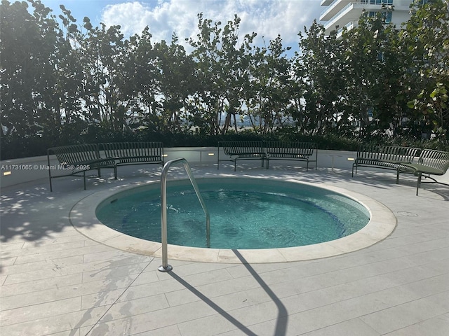 view of swimming pool featuring a patio and an in ground hot tub