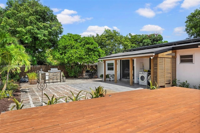 deck with washer and dryer and a patio area