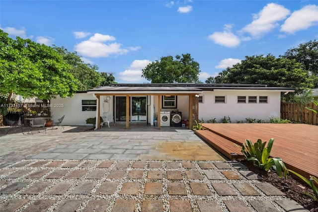 rear view of house featuring washer / clothes dryer, a patio, and a wooden deck