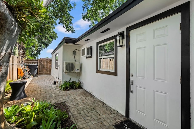 doorway to property with ac unit and a patio area