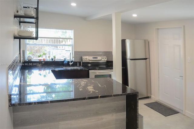 kitchen featuring sink, appliances with stainless steel finishes, dark stone countertops, tasteful backsplash, and white cabinets