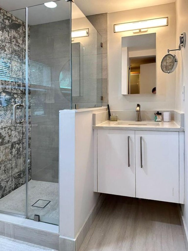 bathroom featuring vanity, hardwood / wood-style flooring, and walk in shower